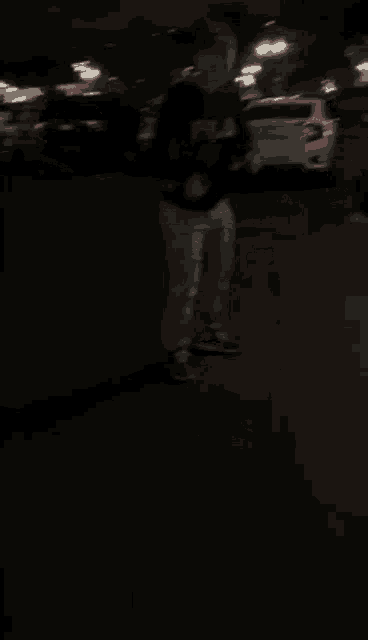 a blurry picture of a person standing in a dark room .