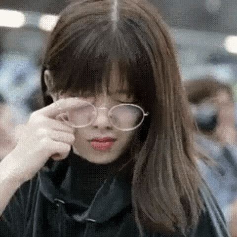 a close up of a woman wearing glasses and a turtleneck .