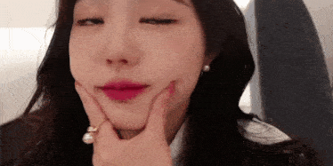 a close up of a woman making a face with her hand on her face .