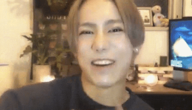 a close up of a person 's face with a tv in the background .