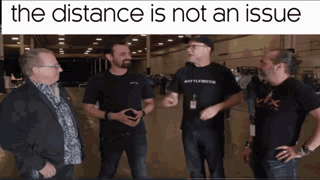 a group of men standing in a warehouse with the words " the distance is not an issue " on top
