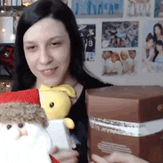 a woman is holding a stuffed santa claus and a stuffed rabbit .