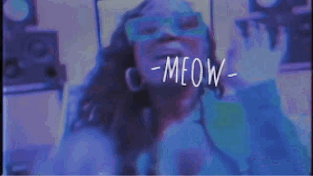 a woman wearing glasses and a mask says meow in a purple room .