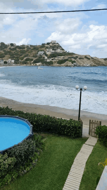 a view of the ocean from a house with a pool in the foreground