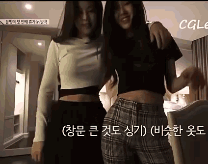 two women are standing next to each other in a room with chinese writing on the bottom of the screen