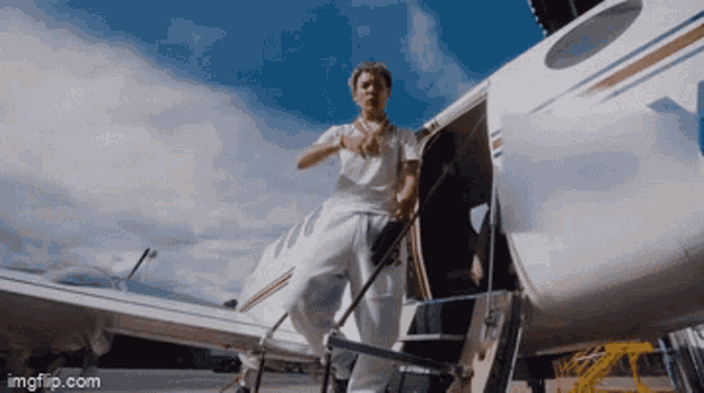 a man standing on the steps of an airplane with imgflip.com in the corner