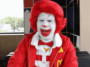 a mcdonald 's clown with a red wig and white face