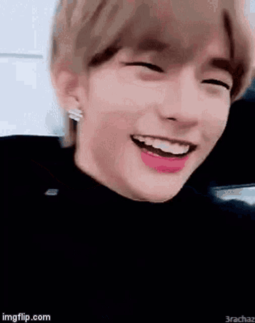 a close up of a person 's face with their eyes closed and a smile on their face .