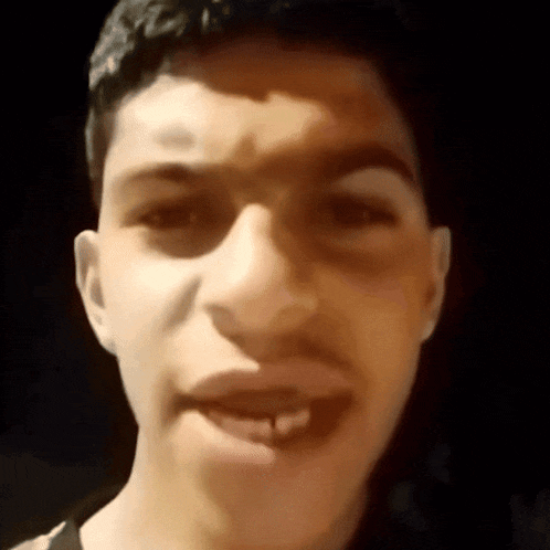 a close up of a man 's face with his mouth open and his teeth showing