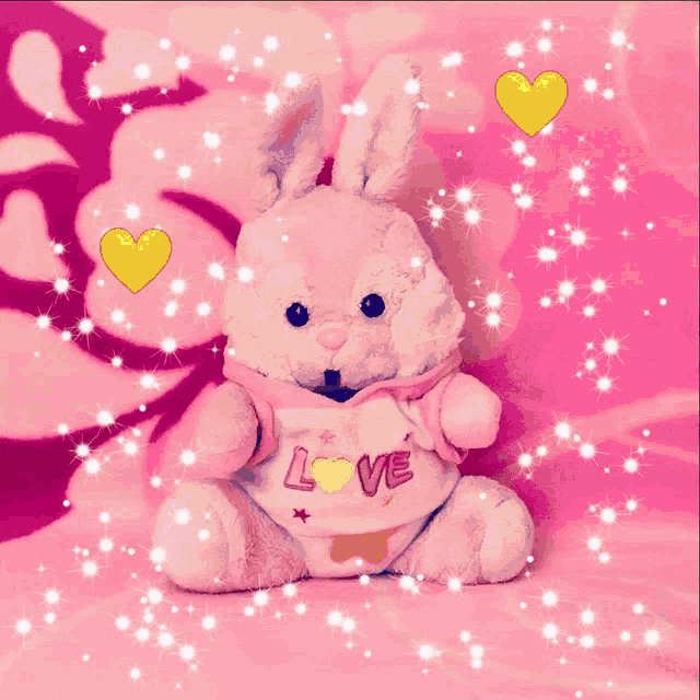 a stuffed bunny wearing a shirt that says love on it
