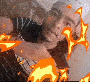 a man in a black and white striped shirt is surrounded by fire