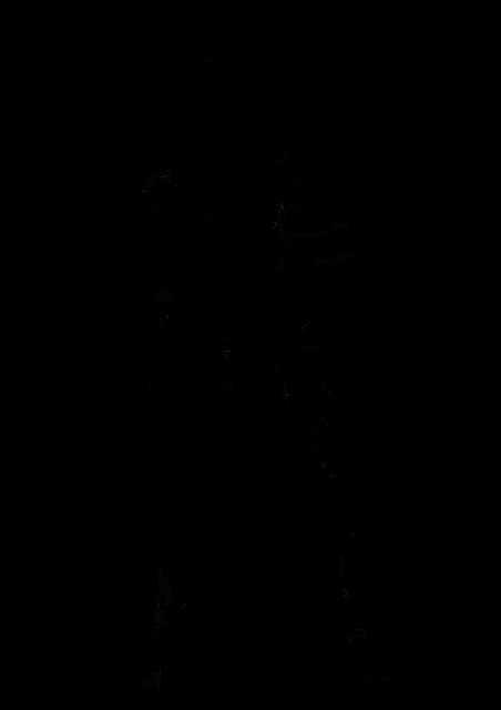 a character from a video game is standing in a dark room with his arms outstretched .