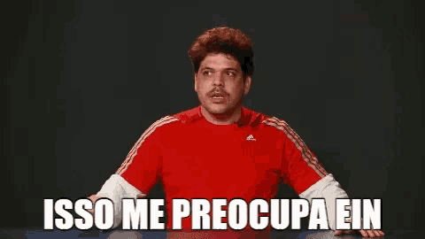 a man wearing a red adidas shirt is sitting at a table
