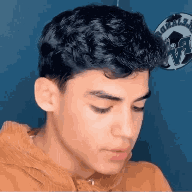 a close up of a young man 's face with his eyes closed and a hoodie on .