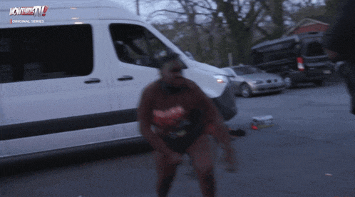 a woman is dancing in front of a white van that says nowthistv on the side