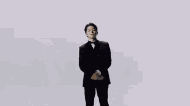 a man in a tuxedo is standing in a row