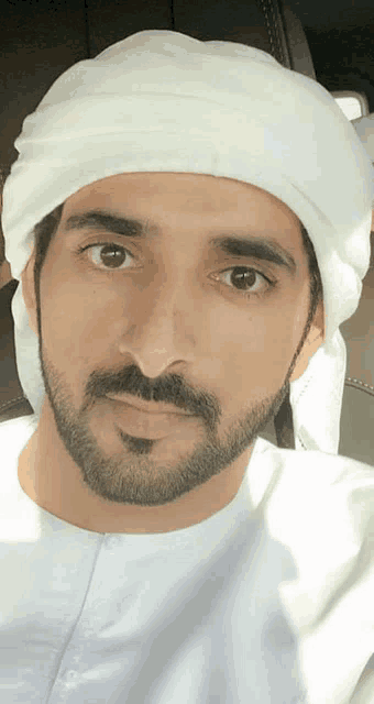 a man with a beard wears a white turban
