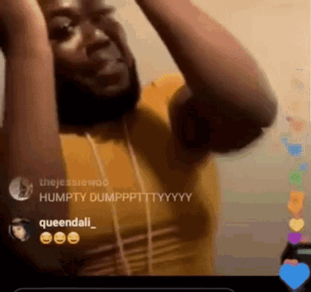 a man with a beard is holding his hands up in the air while wearing headphones .