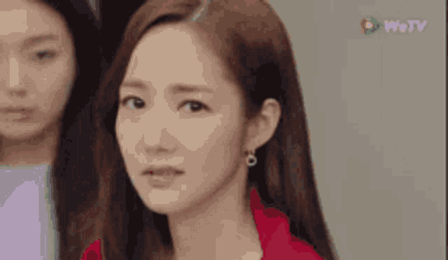 a close up of a woman 's face with a red jacket on .