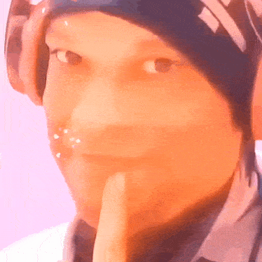 a close up of a person 's face with their finger on their lips