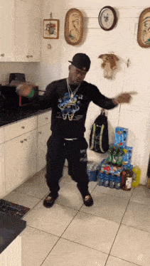 a man is dancing in a kitchen wearing a shirt that says ' i 'm a freak ' on it