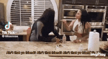 two women are sitting at a kitchen counter talking to each other and the caption says " ain 't that yo friend "