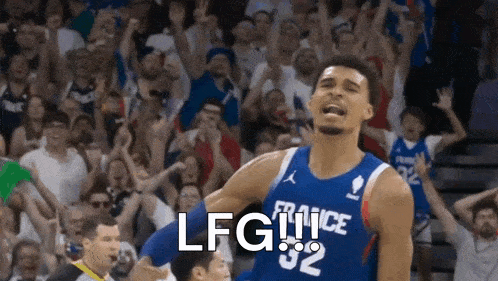 a basketball player in a blue and white jersey with the number 32 on it is standing in front of a crowd .