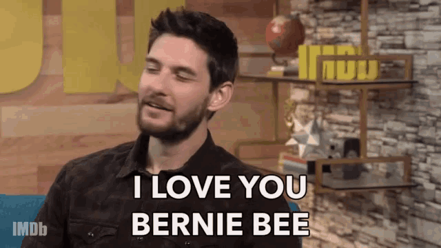 a man says i love you bernie bee while sitting in front of a brick wall