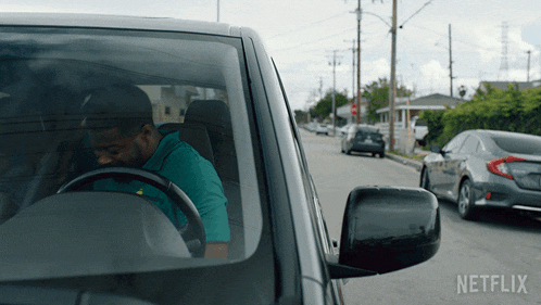 a man driving a car with netflix written on the side of the car