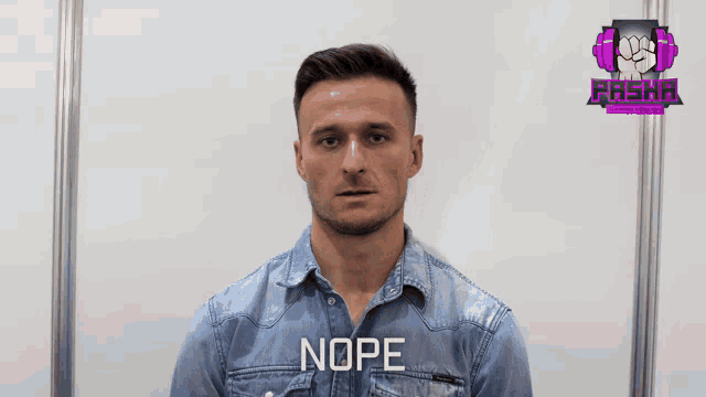 a man wearing a denim shirt with nope written on the front