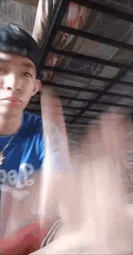 a young man wearing a blue shirt that says gap on it