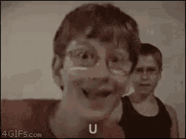 a woman wearing glasses is making a funny face while standing next to a boy .