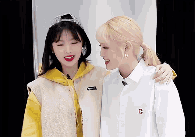 two girls are standing next to each other and one has a letter c on her shirt