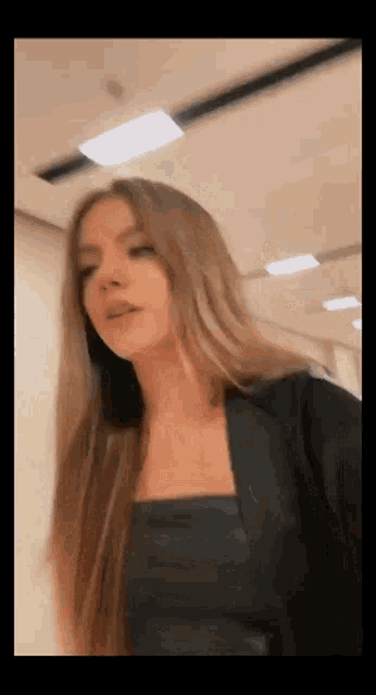 a woman with long hair wearing a black top