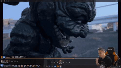 a computer screen shows a video of a monster and a man sitting in a chair