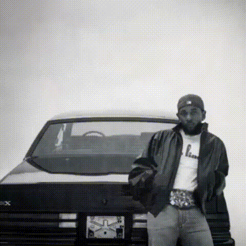 a black and white photo of a man standing next to a black car .