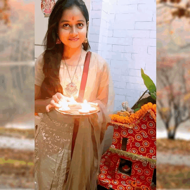 a woman holds a plate of candles in front of a brick wall