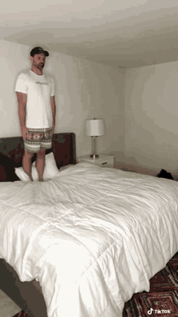 a man standing on top of a bed with a tik tok watermark