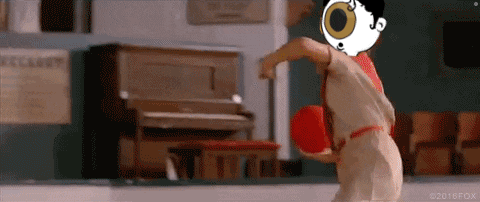 a cartoon character with a big eye is holding a red ball
