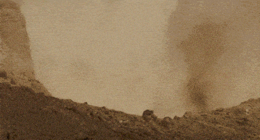 a group of dinosaurs are standing on a dirt hill