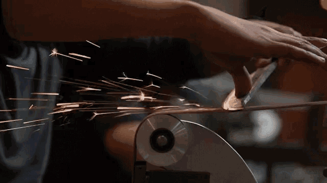 a person is sharpening a knife on a machine