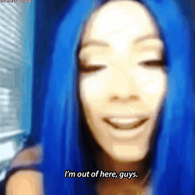 a woman with blue hair is smiling and says i 'm out of here guys .