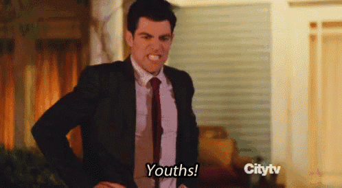 a man in a suit and tie is making a funny face and says youths .