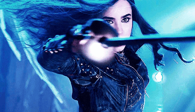 a woman with blue hair is holding a light in her hand