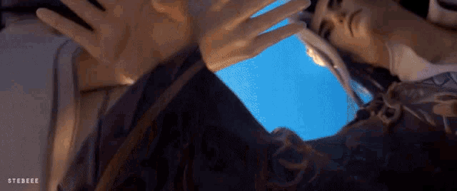 a close up of a person 's hands against a blue sky with the word stereoee on the bottom right