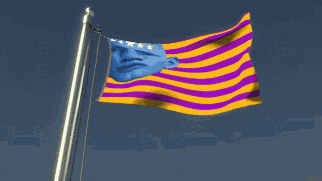 a yellow and purple flag with a blue face on it is flying in the wind