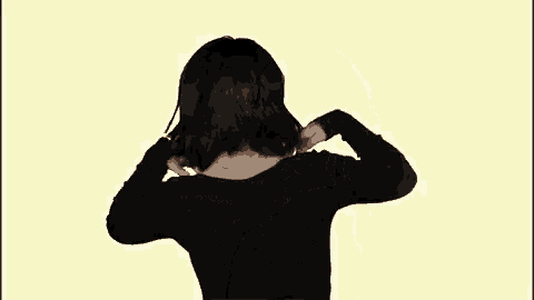 the woman is wearing a black shirt and dancing with her hair blowing in the wind .