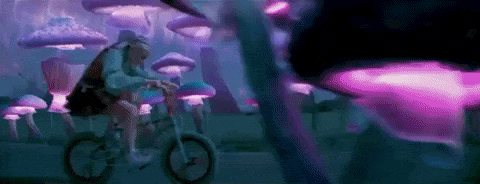 a person is riding a bike in a mushroom forest surrounded by purple mushrooms .