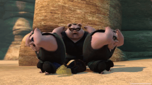 a group of pigs are squatting down in a sandy area