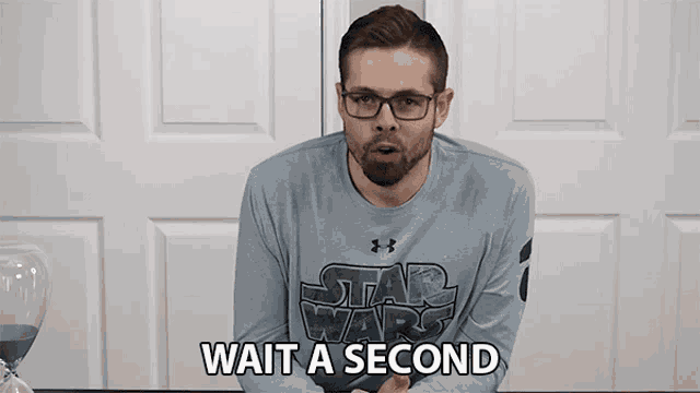 a man wearing a star wars shirt is waiting for a second